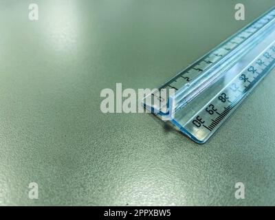 a transparent, long, centimeter ruler lies on the table. supplies for mathematics and geometry. thin ruler with markings with centimeter measurements. Stock Photo