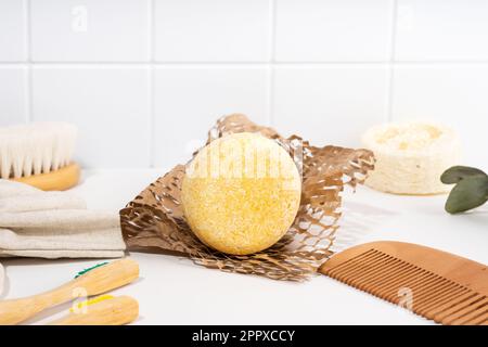 Eco friendly solid shampoo bar and spa accessories in the bathroom. Plastic free, zero waste, low water ingredients on a white ceramic background Stock Photo