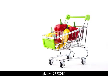 A shopping cart full of different small and large, red and yellow, hot and sweet peppers.  The concept of selling and buying food.  Isolated on white Stock Photo