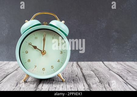 Vintage retro alarm clock ten time o'clock on table wood with dark background. Stock Photo