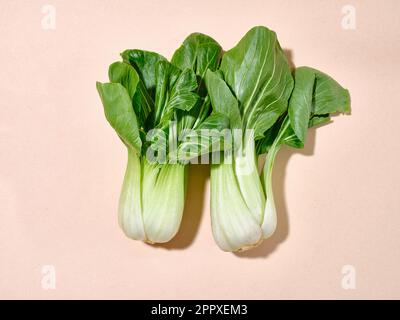 Bok choy cabbage in sunlight top view on warm beige background Stock Photo