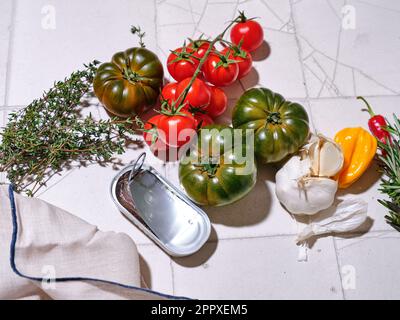 Flat lay with fresh vegetables on tiled background. Cooking healthy lunch with various tomatoes and herbs Stock Photo