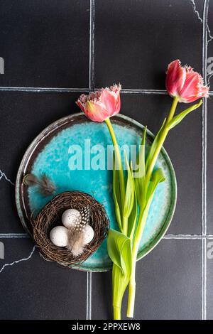 Top view of table setting with fresh tulip flowers on black concrete background Stock Photo