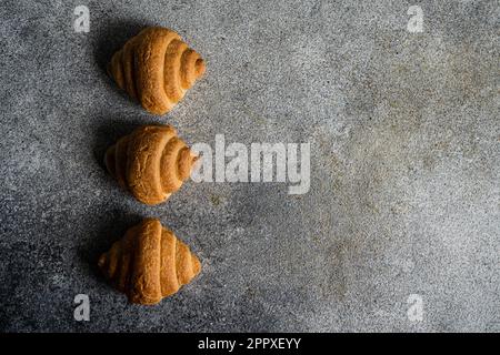 Top view of fresh baked croissants on the concrete background Stock Photo