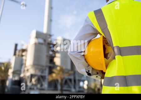 crop anonymous African American female engineer in uniform and helmet standing on construction site during work Stock Photo