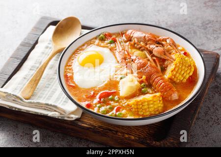 Crayfish soup with tomatoes, corn, pepper, potato and egg close-up in a bowl on the table. Horizontal Stock Photo