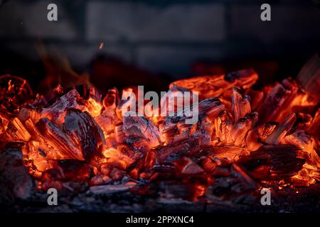 Flame of fire from hot burning coals in the fireplace. Heat from the oven. Stock Photo
