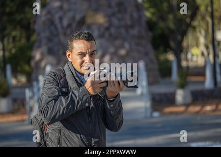 Portrait of a photojournalist working on the street. Stock Photo