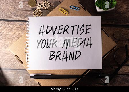 Closeup on notebook over vintage desk surface, front focus on wooden blocks with letters making Build Your Personal Brand text. Business concept image Stock Photo
