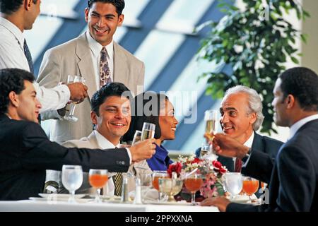 A group of multicultural executives celebrating with glasses of champagne during a business luncheon Stock Photo