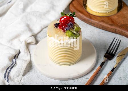 Cream cake surrounded by chocolate. Chocolate and fruit cake on gray background. Studio shoot. Bakery products Stock Photo
