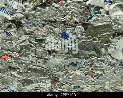 Moscow, Russia, November 2022: Flattened elements from food packaging made of foil and aluminum. Conscious consumption and garbage sorting concept. Stock Photo