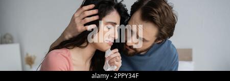 Caring man hugging upset girlfriend crying at home, banner,stock image Stock Photo