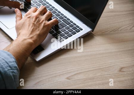 Man's hands typing on laptop keyboard top view Stock Photo