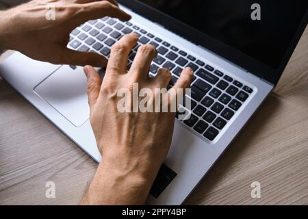 Man's hands typing on laptop keyboard top view Stock Photo