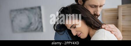 Bearded man calming sad and crying girlfriend at home, banner,stock image Stock Photo
