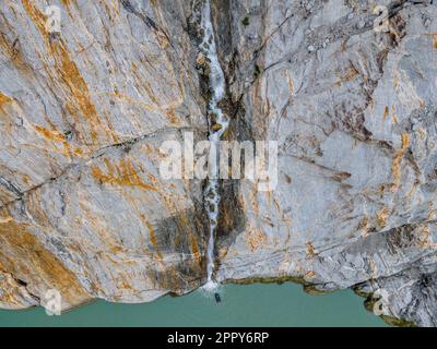 Wide aerial top down view of a zodiac with tourist viewing Misty Fjords waterfall in Misty Fjords National Monument Wilderness. Stock Photo