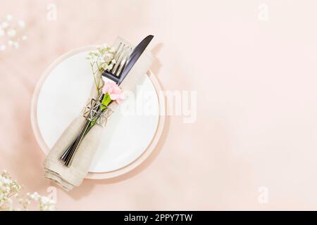 Spring holiday table settings on light pink background with spring white flowers Stock Photo