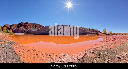 The red water of Lithodendron Wash in Petrified Forest National Park Arizona. The red color is from the bentonite clay in the surrounding hills. Stock Photo