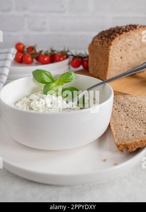 Cottage cheese salad with herbs and olive oil. Served with rye bread. Healthy low fat and protein meal Stock Photo