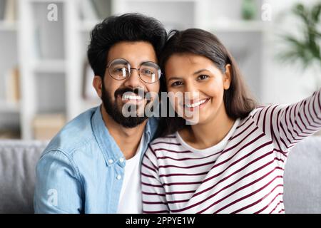 Happy cute young indian couple taking selfie at home Stock Photo