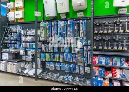 Carmagnola, Turin, Italy - April 24, 2023: shelves with bathroom accessories, shower elements, packaged taps and fittings for sale in DIY store Stock Photo