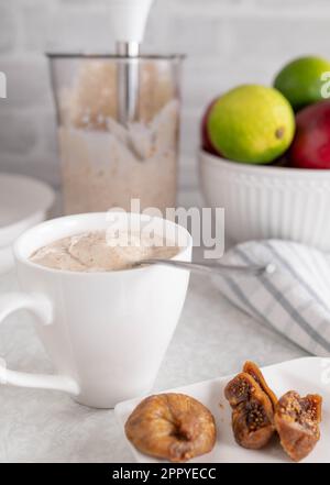 Yogurt with dried figs in a cup on kitchen counter Stock Photo