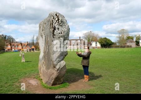 Female dowser capturing the earth energies at Avebury stone circle, Wiltshire, UK - John Gollop Stock Photo