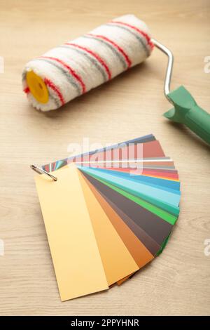 Coloured swatches and paint roller on table. Top view Stock Photo