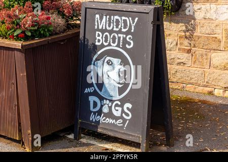Muddy Boots and Dogs Welcome sign on a chalkboard outside a British country pub welcoming walkers. Stock Photo