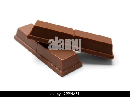 Crispy chocolate bars one on top of the other on a white background close-up. Sweet bars in milk chocolate close-up. Dessert. Snack. Calorie foods. Stock Photo