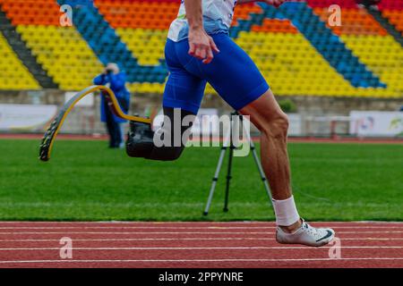 male runner para-athlete on Nike prosthesis and spikes shoes running track stadium, summer para athletics championships Stock Photo