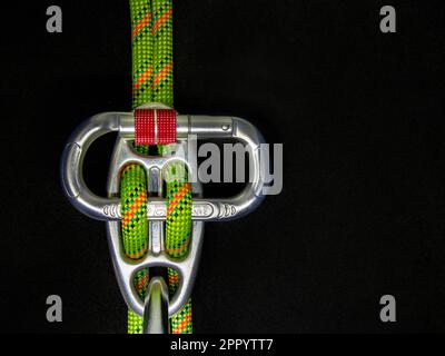 Gigi tag discensor with oval carabiner on a Black dark background in double rope abseilling Stock Photo