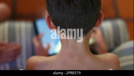 Child playing video-game on tablet device. Young boy absorbed by tech game Stock Photo
