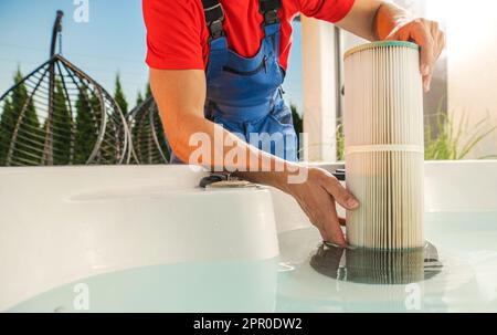 Technician Replacing Hot Tub Water Filter During Spring Time Cleaning and Maintenance. Stock Photo