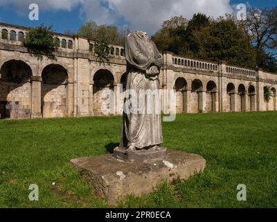 Dante, headless marble statue in Crystal Palace Park. First recorded in the park in 1864. Wide 3/4 angle of figure against classical arches. Stock Photo