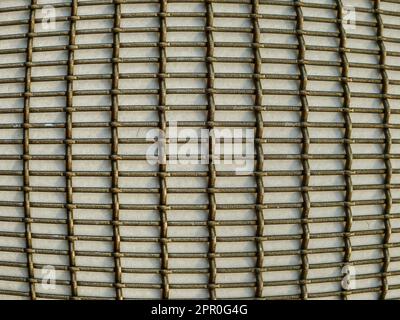 Close-up of a convex bronze metal grid pattern on a wall Stock Photo