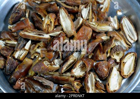 A tray with cracked dried dates fruit, Ramadan dried fruits Yameesh of dried dates that is used in Ramadan Khoshaf or compote that the fasting Muslims Stock Photo