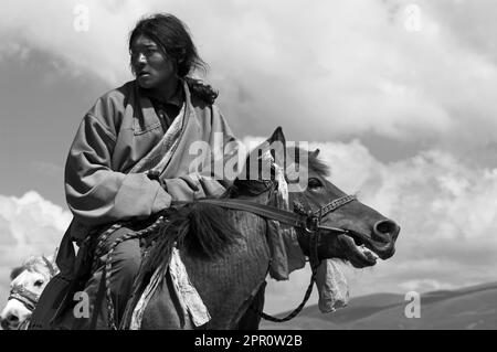 Khampas, the warrior horseman of old Tibet,  compete at the Litang Horse Festival - Kham, Sichuan Province, China, (Tibet) Stock Photo