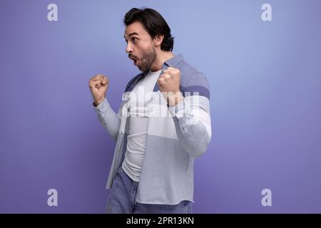 emotional young brutal brunette guy on a studio background for a poster Stock Photo