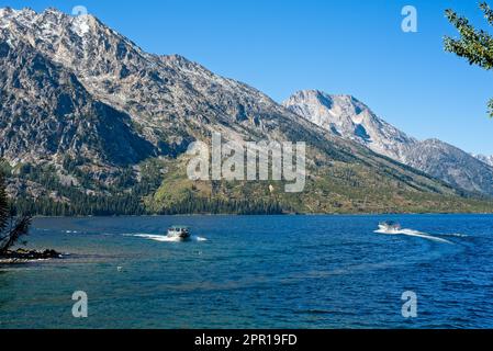 Shuttle boats on Jenny Lake in Grand Teton National Park pass each other while ferrying passengers to and from the far side of the lake. Stock Photo