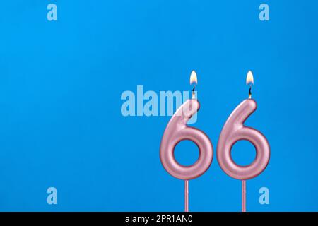 Candle number 66 - Birthday in blues foamy background Stock Photo