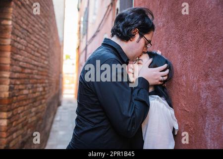 Boyfriend kisses his girlfriend's forehead, mixed couple, moment of passion Stock Photo