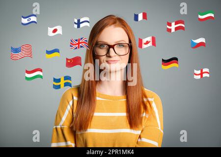 Portrait of interpreter and flags of different countries on grey background Stock Photo