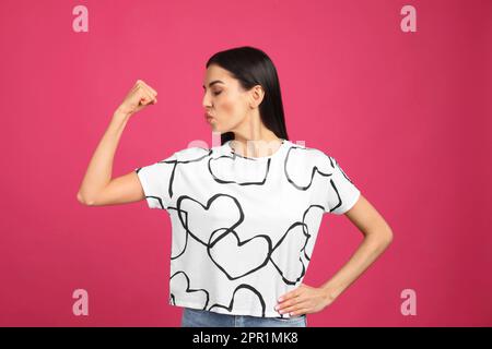 Strong woman as symbol of girl power on pink background. 8 March concept Stock Photo