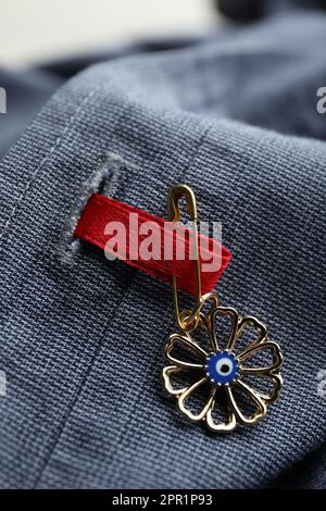 Evil eye safety pin on denim clothing, closeup Stock Photo - Alamy
