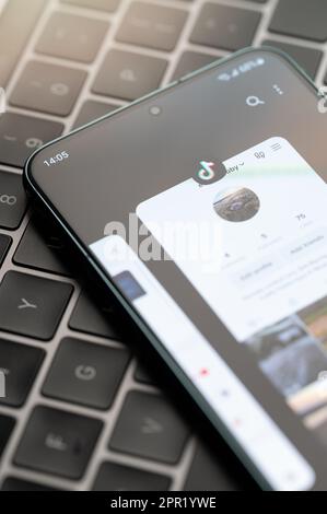 New york, USA - April 25, 2023: Tik tok menu app on smartphone screen close up view keyboard background Stock Photo