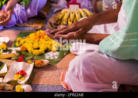 Hindu puja rituals being performed with flowers in front of priest during pooja, wedding, funeral ceremonies. Miscellaneous religious essentials are k Stock Photo