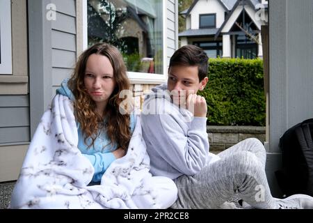 Sad pensive young girl thinking of relationships problems sitting on sofa with offended boyfriend, conflicts in friendship upset couple after fight dispute making decision of breaking up get divorced Stock Photo