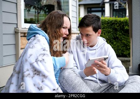 Sad pensive young girl thinking of relationships problems sitting on sofa with offended boyfriend, conflicts in friendship upset couple after fight dispute making decision of breaking up get divorced Stock Photo